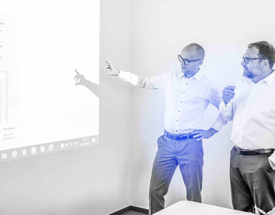 Drei Männer besprechen sich vor Leinwand | Abacus neo in Frankenthal